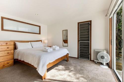 a bedroom with a large bed and a window at Karaka Sanctuary with Spa Pool by Waiheke Unlimited in Oneroa