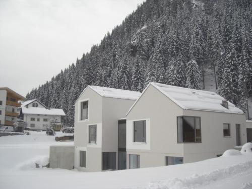 a house in the snow in front of a mountain at Laudinella - Apart in See