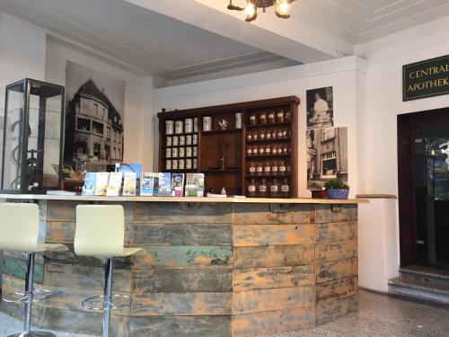 a bar with two white chairs in a room at Central Pension in Duisburg