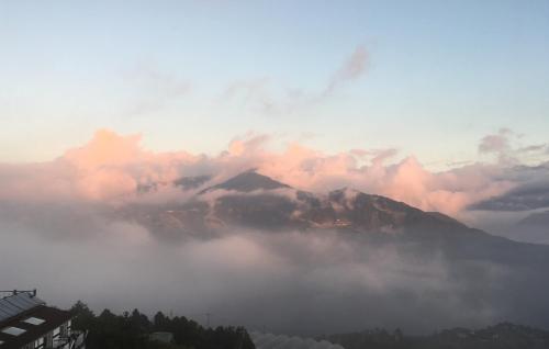 a view of a mountain in the clouds at The Cotswolds Villa in Renai