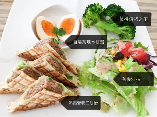 een bord met een salade en broodjes en broccoli bij Ming Yuan B&B in Wujie
