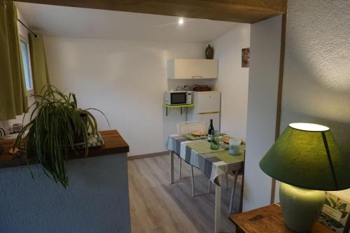 sala de estar con mesa y cocina en Gite 3* pour 2 "Vert Campagne", en Grézillé