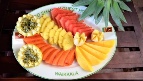 un plato de frutas y hortalizas en una mesa en Rico Shadow Guest House & Restaurant, en Wayikkal