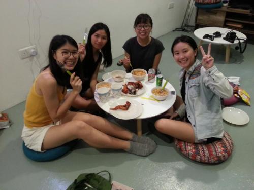 a group of girls sitting around a table eating food at Space Cap Hotel in Kota Kinabalu
