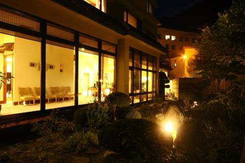 a building with windows and a patio at night at Kashoutei Hanaya in Noboribetsu