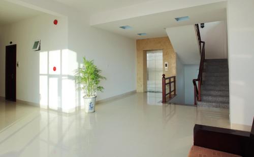 a hallway with a potted plant in a building at Gold Stars Hotel in Long Hai
