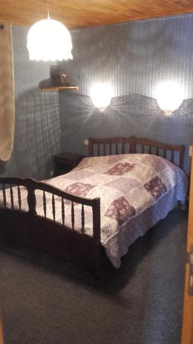 - une chambre dotée d'un lit en bois avec deux lumières dans l'établissement La Grande Lauze, à Champcella