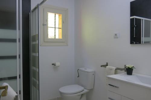 ベニッサにあるVilla Sonsolesのバスルーム(トイレ、洗面台付)、窓が備わります。