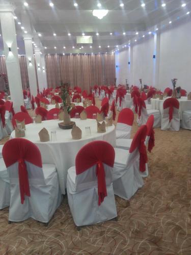 a banquet hall with white tables and red chairs at Green Shadows Beach Hotel in Kalutara