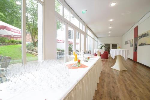 a large room with a long counter with wine glasses at Best Western Plus Hotel Am Schlossberg in Nürtingen