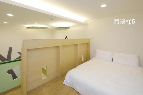 a bedroom with a bed with a wooden headboard at Happiness Yes Inn in Luodong