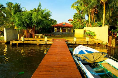 a boat is docked at a dock in the water at Bentota River Villa in Bentota