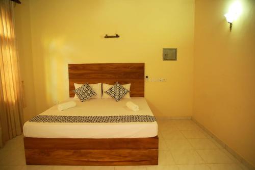 a bedroom with a bed with a wooden headboard and pillows at Bentota River Villa in Bentota