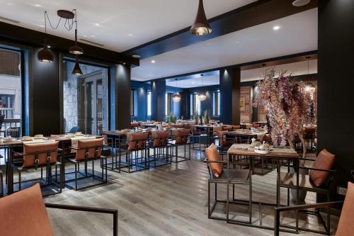 un restaurant avec des tables et des chaises dans une salle dans l'établissement Whistler Lodge by Alpine Resorts, à Courchevel