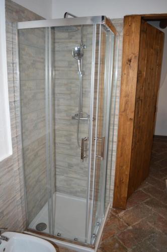 een douche met een glazen omhulsel in een badkamer bij Il pensiero in Lenno