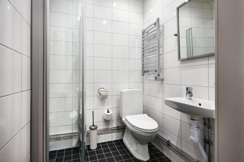 a white bathroom with a toilet and a sink at Hotel Hornsgatan in Stockholm