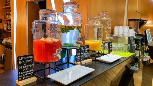 a group of glass jars filled with different colored drinks at Rest Apartments in Wrocław