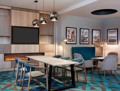a conference room with a table and chairs and a tv at Leonardo Hotel Southampton in Southampton