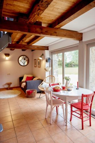 un salon avec une table et des chaises blanches dans l'établissement Manoir des petites bretonnes, à Saint-Quay-Perros