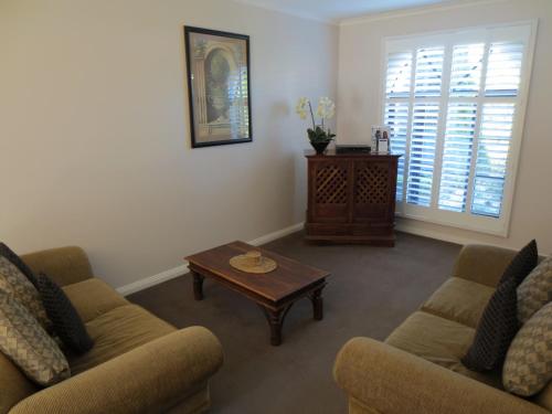 a living room with two couches and a coffee table at Gallery Apartments in Warrnambool