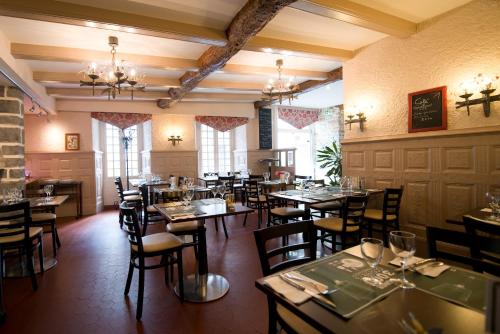 a restaurant with tables and chairs in a room at La Croix Verte - Le Relais des Moulins in Bain-de-Bretagne