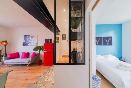 a living room with a red refrigerator and a couch at Le Boz'art in Montpellier