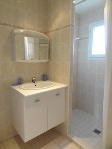 une salle de bain blanche avec un lavabo et une douche dans l'établissement Maison Porcelaine, à La Couarde-sur-Mer