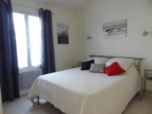 ラ・クアルド・シュル・メールにあるMaison Porcelaineのベッドルーム1室(赤と青の枕が備わるベッド1台付)