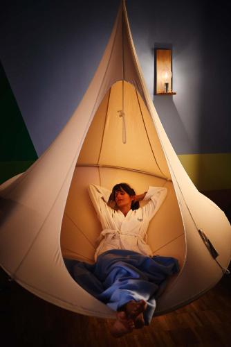 a woman is laying in a teepee tent at Hotel Zugbrücke Grenzau GmbH in Höhr-Grenzhausen