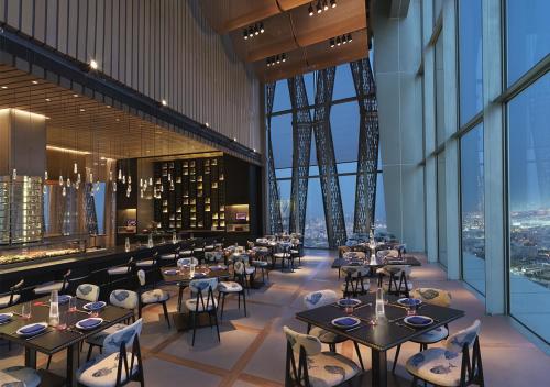 a dining room with tables and chairs and a tower at Four Seasons Hotel Kuwait at Burj Alshaya in Kuwait