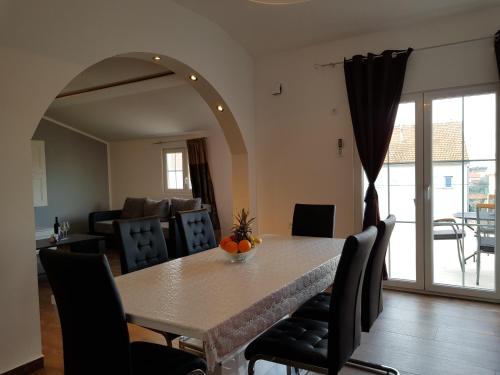 a dining room with a table with chairs and a room with a dining room at Apartment Jopa in Šibenik