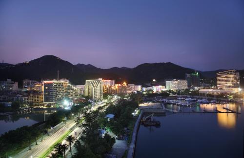 a city skyline at night with a river and buildings at Shenzhen Dameisha Kingkey Palace Hotel in Shenzhen