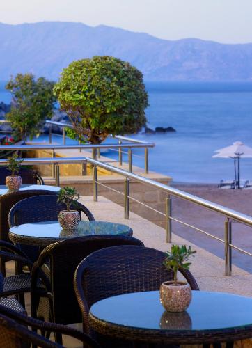 a group of tables and chairs with a view of the ocean at Molos Bay Hotel in Kissamos