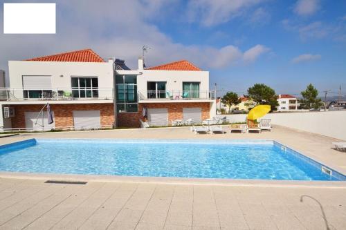 a swimming pool in front of a house at Bela Baïa in Salir de Porto