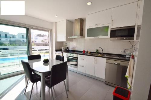a kitchen with a table and a table and chairs at Bela Baïa in Salir de Porto