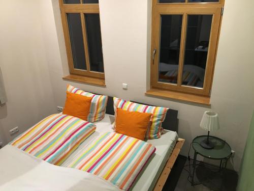 ノイシュタット・アム・リューベンベルゲにあるFerienwohnung im Kuhstallの窓際のベッド(カラフルな枕付)