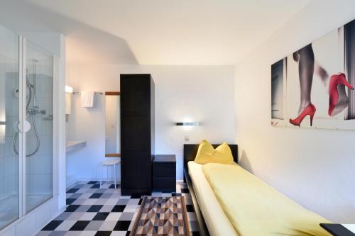 a bedroom with a bed and a checkerboard floor at Schlosshotel - Self Check-In Hotel in Brig