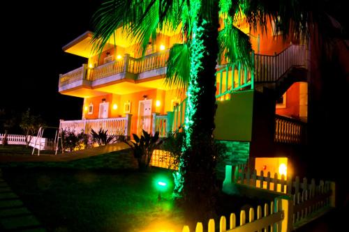 a house with a palm tree in front of it at night at Studio Konstantinos in Parga