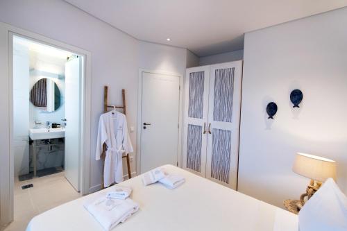 a white bedroom with a bed and a sink at Crystal Waters in Nikiana