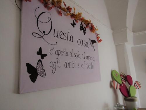 a sign on a wall with butterflies on it at up in Carosino