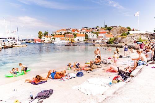 a group of people laying on the sand at a beach at Tollboden Hotell - Unike Hoteller in Kragerø