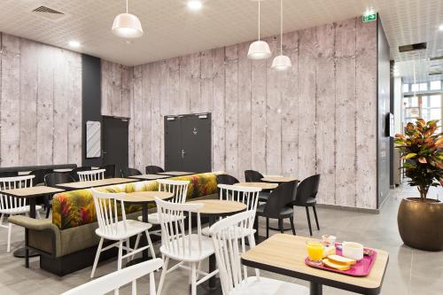 a restaurant with tables and chairs in a room at B&B HOTEL LYON Centre Perrache Berthelot in Lyon