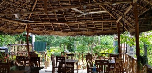 a table and chairs under a thatched roof at Turtle Paradise in Tangalle
