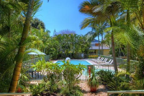 un complejo con piscina y palmeras en Bila Vista Kirra Beachside Apartments, en Gold Coast