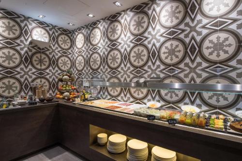 un restaurante con un mostrador con platos en Catalonia Magdalenes, en Barcelona