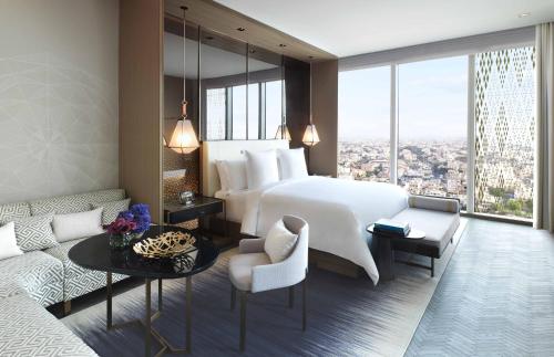 a hotel room with a large bed and a couch at Four Seasons Hotel Kuwait at Burj Alshaya in Kuwait