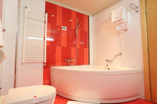 a bathroom with a tub and a toilet at Hotel Zenica in Zenica