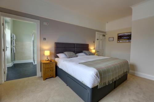 a bedroom with a large bed and a walk in shower at The Grange Guest House in Brecon