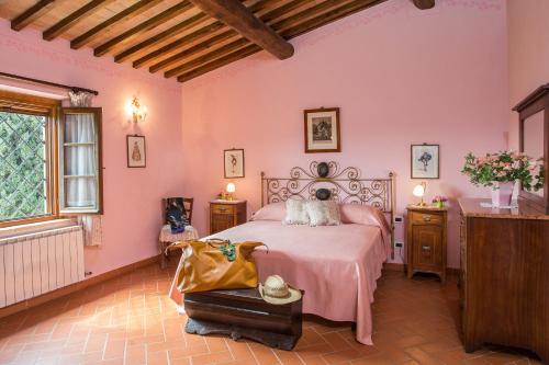 a bedroom with pink walls and a bed and a window at Ormanni nel Chianti Classico in Barberino di Val dʼElsa