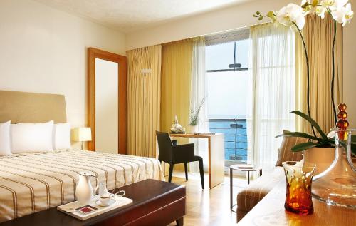 a hotel room with a bed and a desk and a window at Daios Luxury Living in Thessaloniki